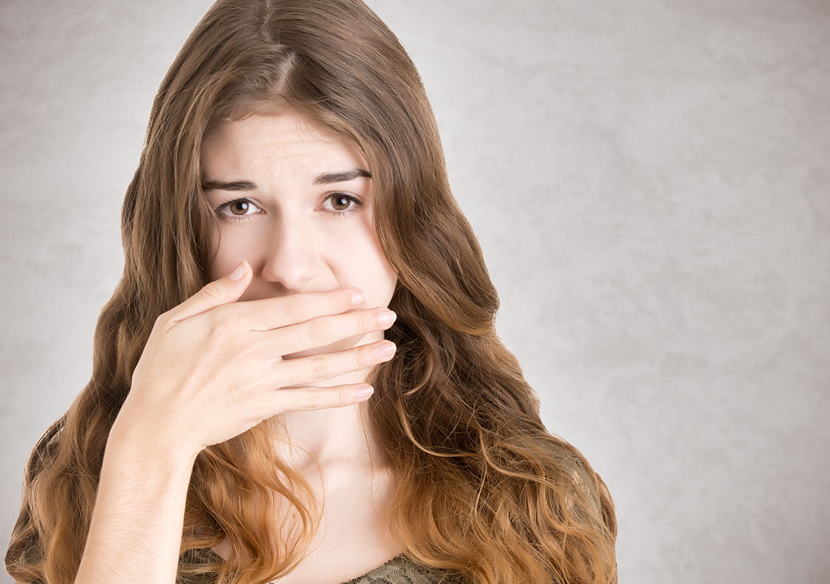 a woman is covering her mouth