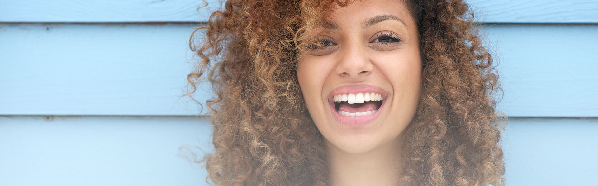 A beautiful woman is smiling after having cosmetic dentistry treatment